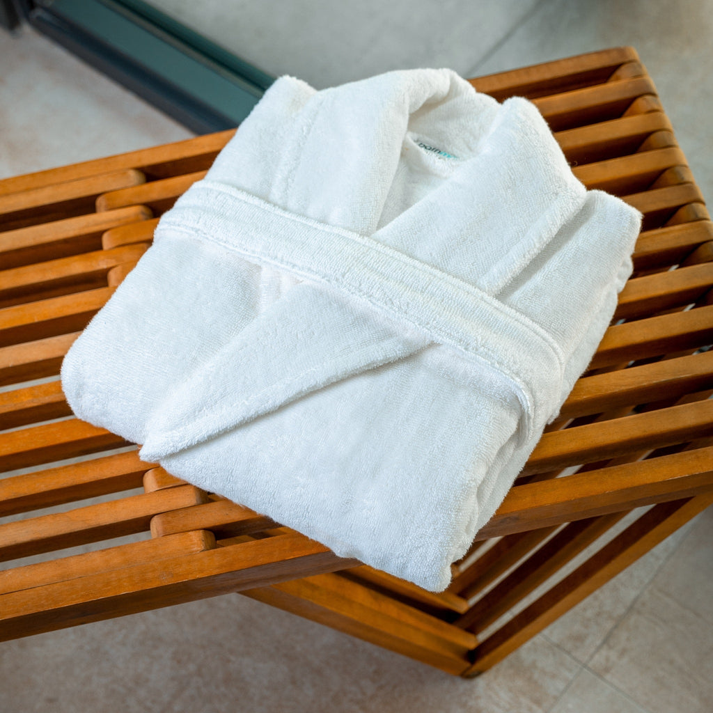 White bathrobe folded on a wooden bench