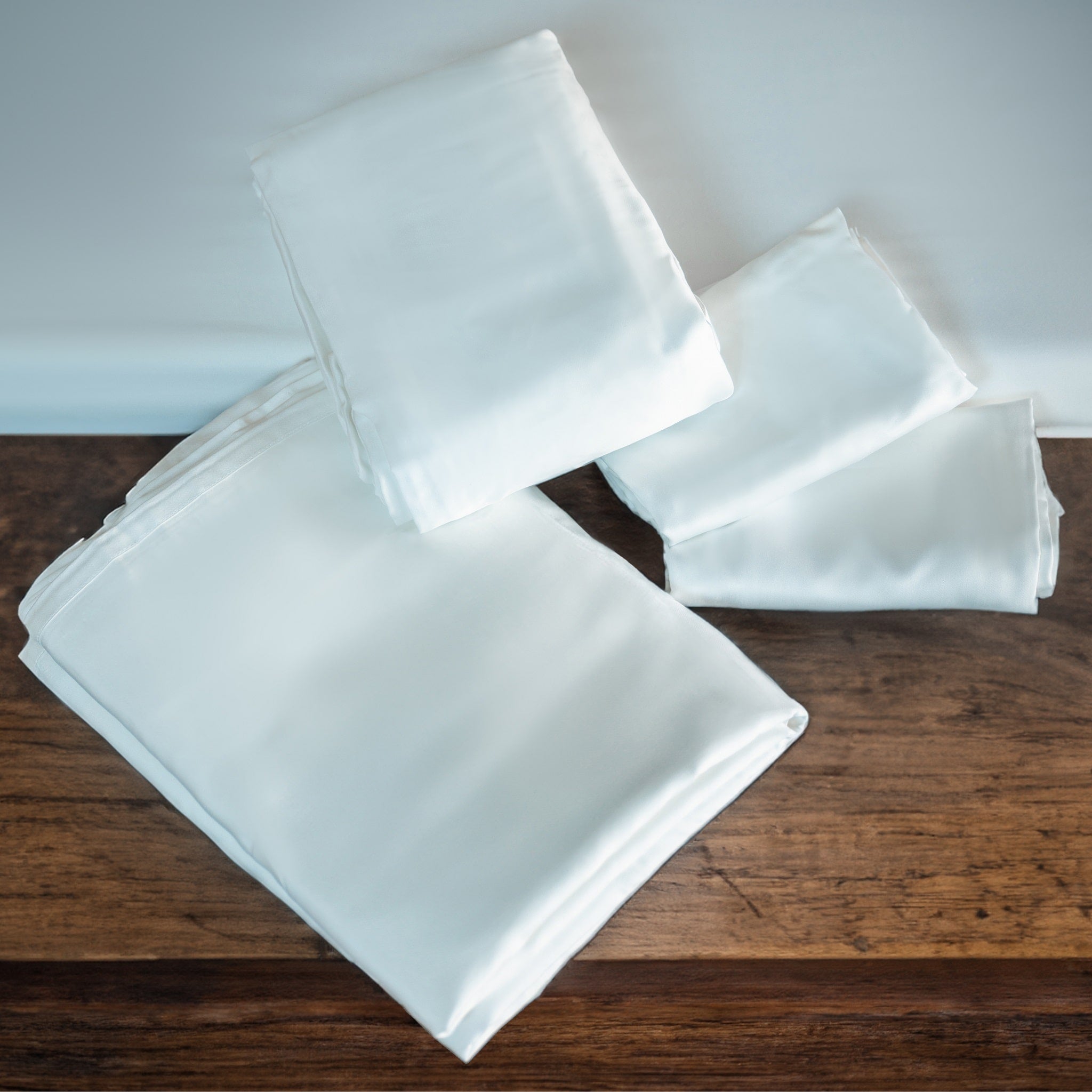 White sheets on a wooden surface with a white background